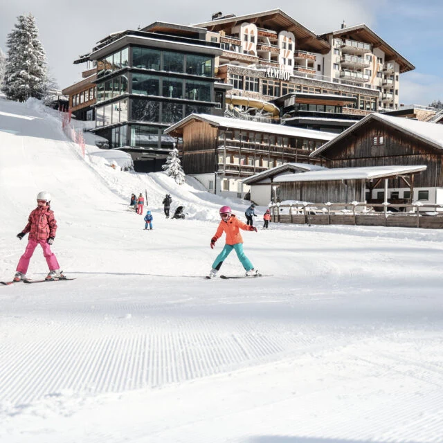 Skifahrende Kinder im verschneiten Skigebiet