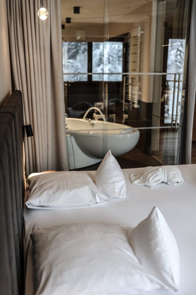 Gemütliches Bett mit Blick auf Badezimmer.