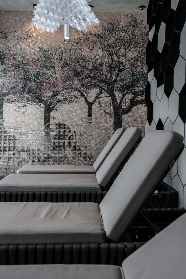 Modernes Spa mitRelaxliegen und künstlerischer Wandgestaltung