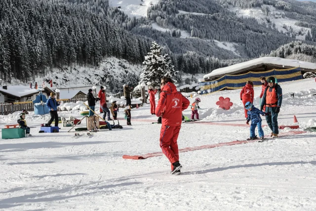 Skifahrer und Kinder auf einem verschneiten Hang