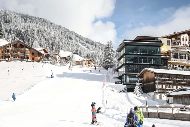Skigebiet mit verschneiten Pisten und Hütten.
