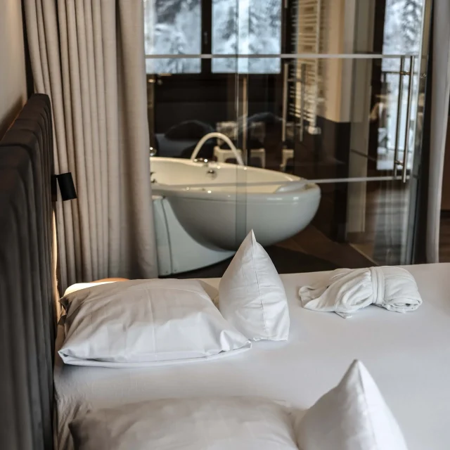 Gemütliches Bett mit Blick auf Badezimmer.