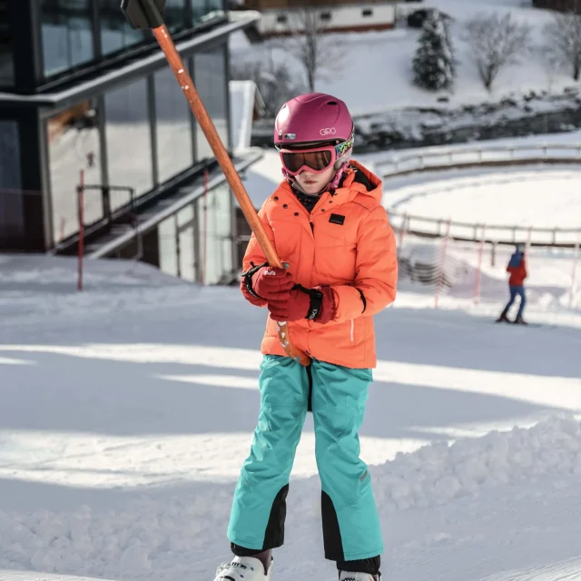 Kind steht auf Skiern in der Schneelandschaft