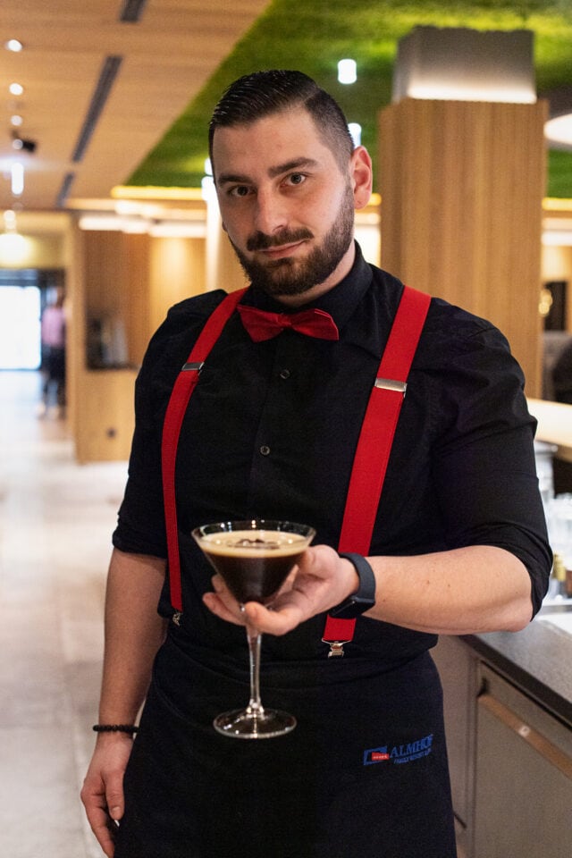 Kellner mit Cocktail in stilvollem Restaurant.