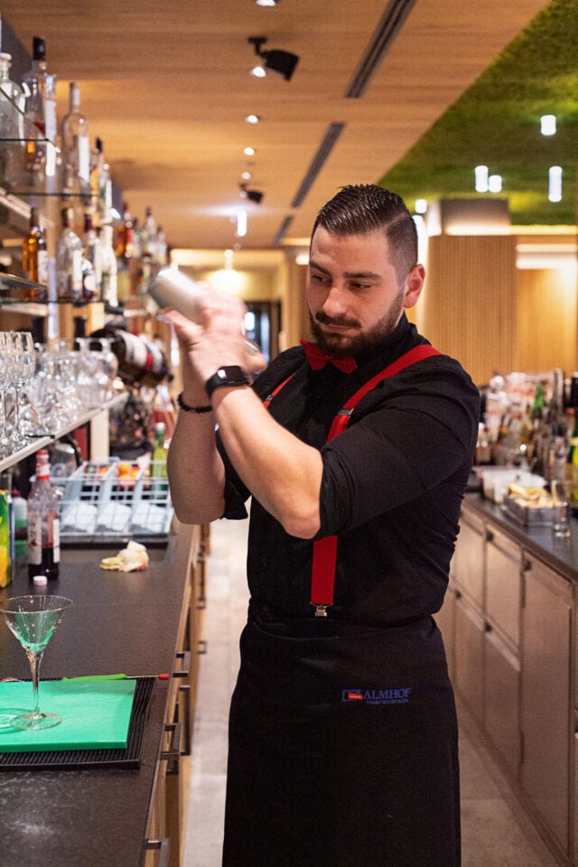 Bartender mixet einen Cocktail hinter der Bar.