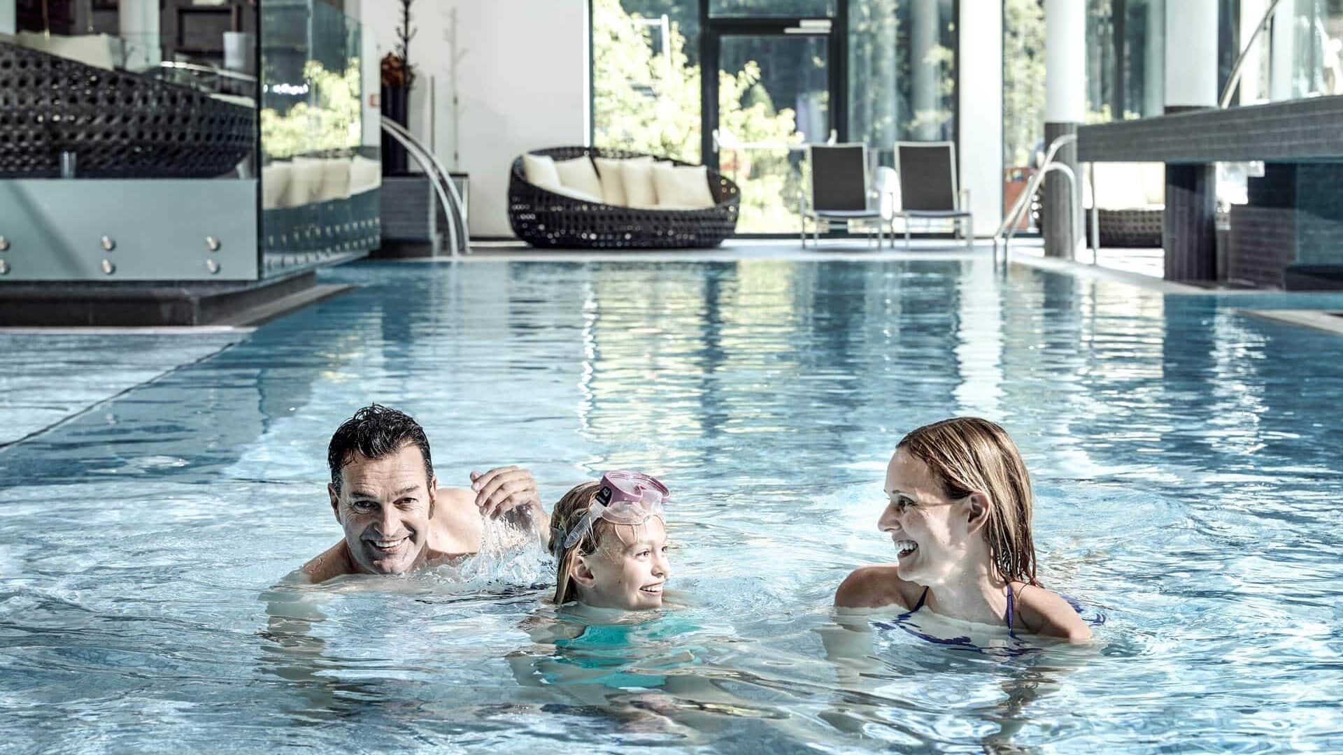 Familie schwimmt im Pool mit Spaß.