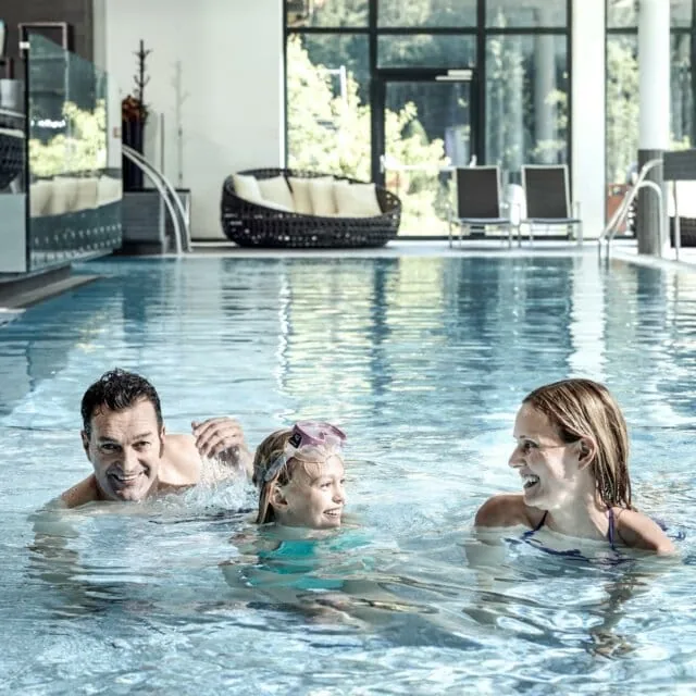 Familie schwimmt im Pool mit Spaß.