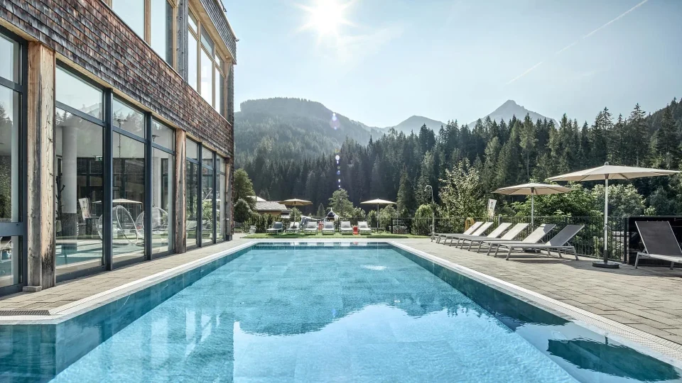 Schöner Pool mit Bergblick und Sonnenschirmen.