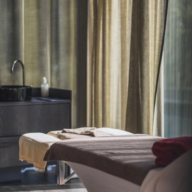 Entspannungsbereich mit Massagetisch und Vorhängen