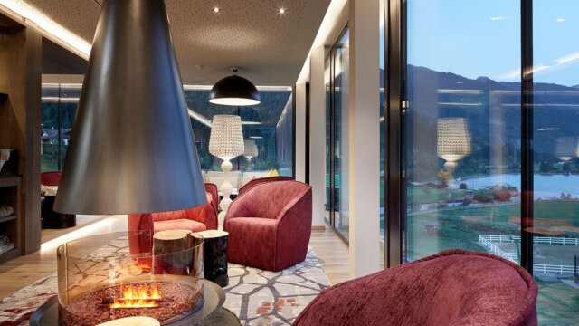 Moderne Lounge mit Kamin und Blick auf die Natur