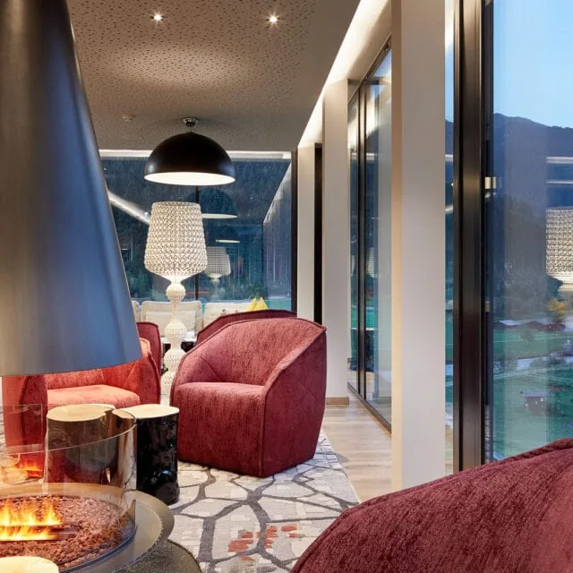 Moderne Lounge mit Kamin und Blick auf die Natur