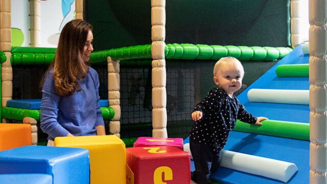 Kleinkind spielt mit Bauklötzen und Rutsche.