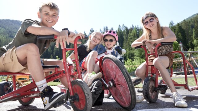 Kinder auf Dreirädern im Freien