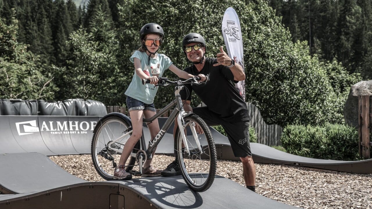 Vater und Tochter auf Fahrrädern im Freizeitpark.