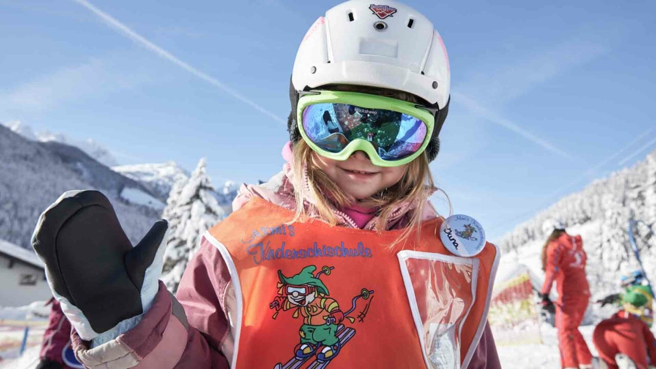 Ein Mädchen in Skiausrüstung mit Handschuhen.