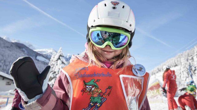 Ein Mädchen in Skiausrüstung mit Handschuhen.