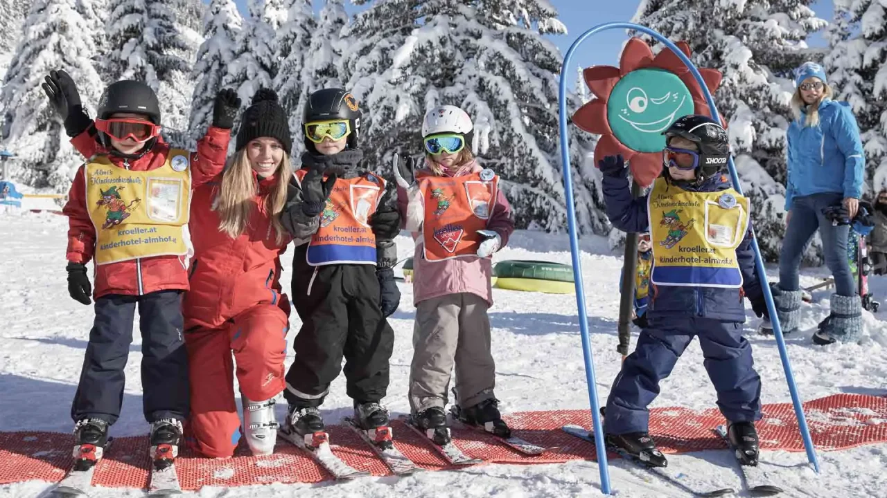 Kinder beim Skifahren im Schnee, fröhlich posierend.