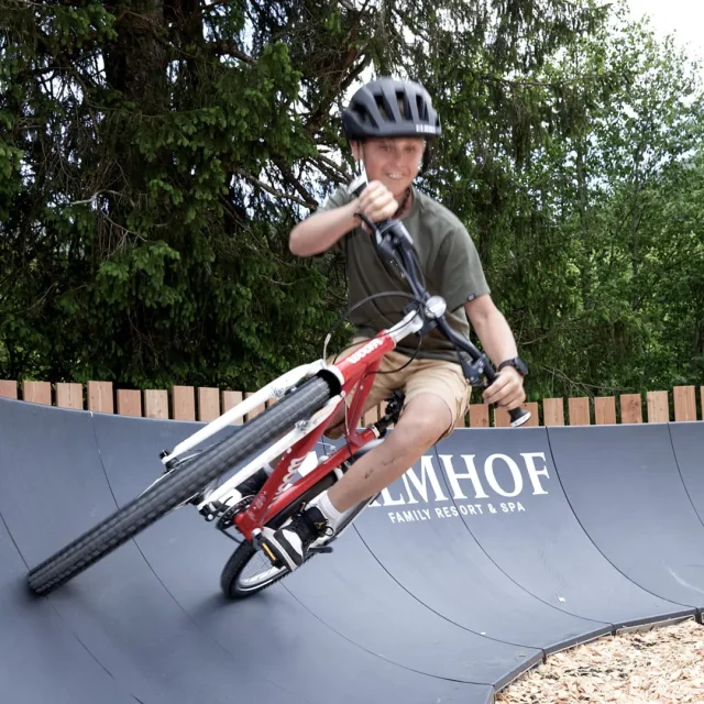 Junge fährt Fahrrad auf einer Wellenbahn.