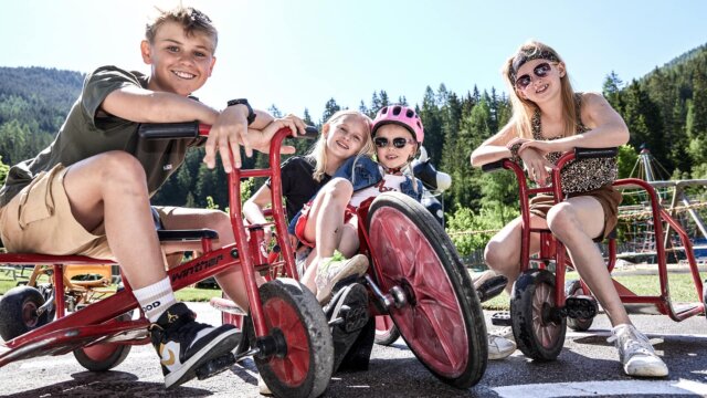 Kinder mit Dreirädern im Freien