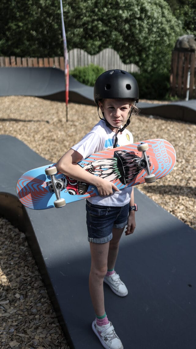 Mädchen mit Skateboard in einem Skatepark.