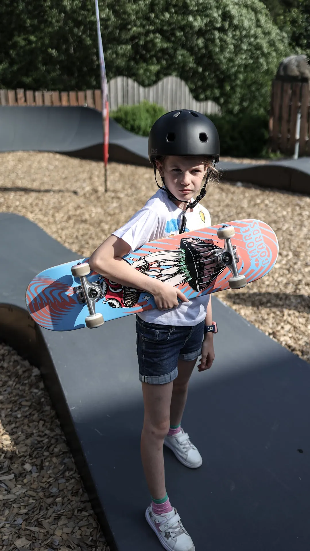 Mädchen mit Skateboard in einem Skatepark.