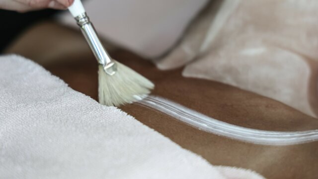 Hautpflege mit einem Pinsel und Lotion.