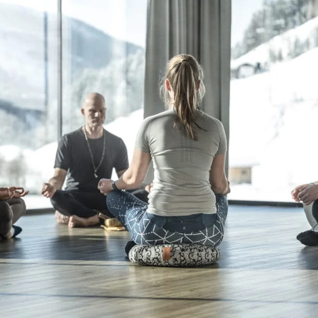 Meditation in einem hellen Raum mit Ausblick.