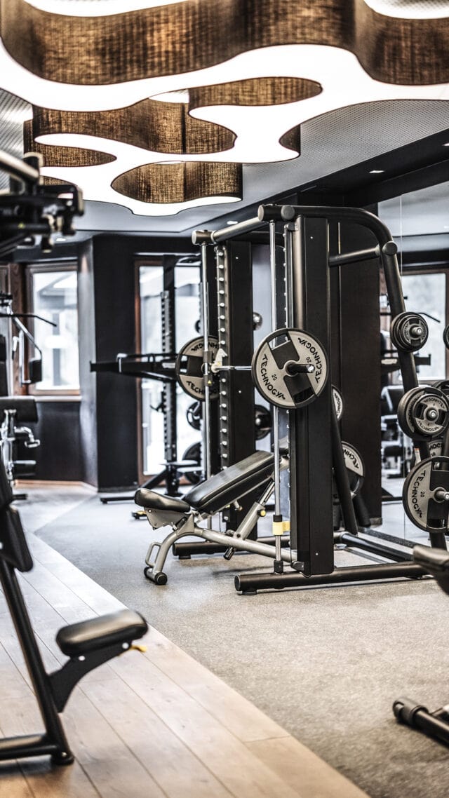 Modernes Fitnessstudio mit Gewichten und Geräten.