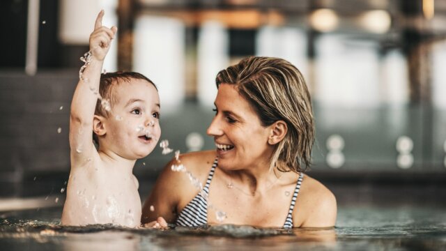 Mutter spielt mit Kind im Wasser