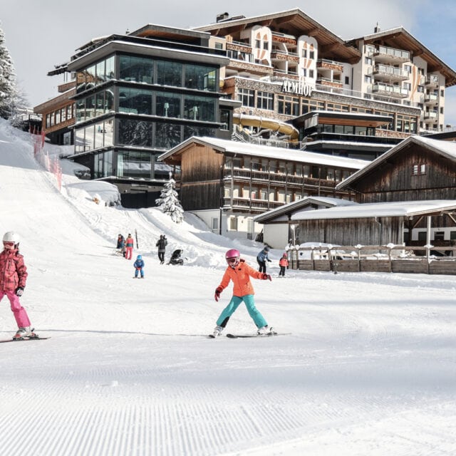 Kinder beim Skifahren in schneebedecktem Gebiet.