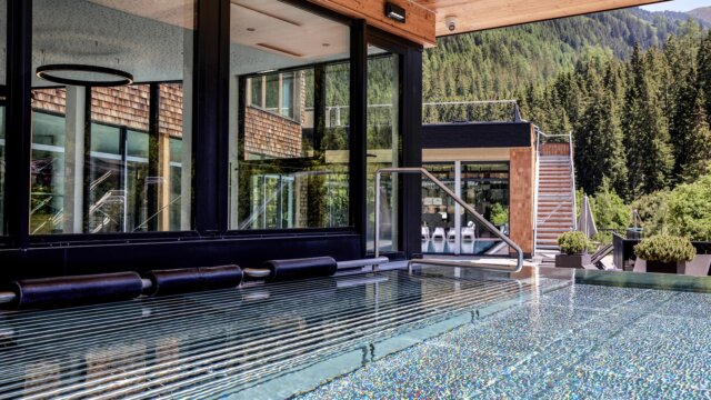 Moderner Pool mit Bergblick und Glaswänden