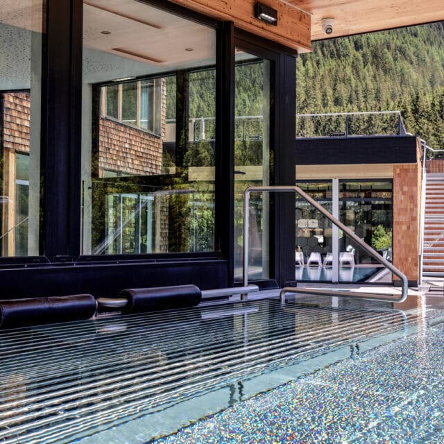 Moderner Pool mit Bergblick und Glaswänden