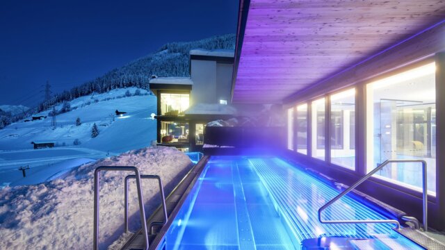 Beheizter Pool in verschneiter Landschaft bei Nacht