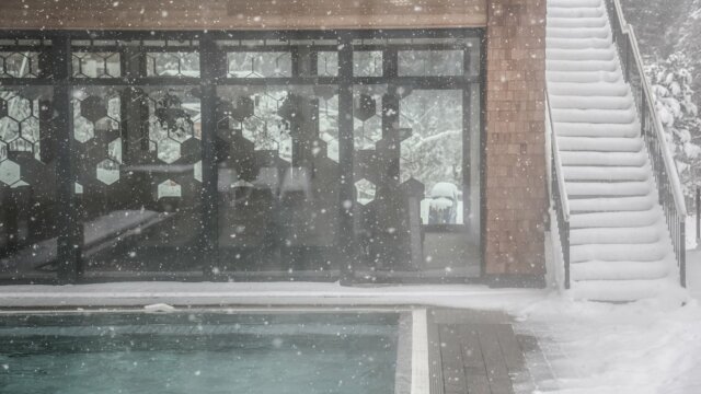 Schneebedecktes Gebäude neben einem Pool