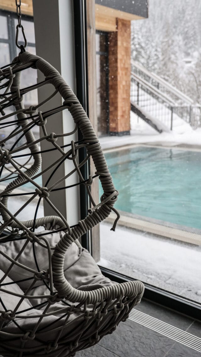 Schaukelstuhl mit Blick auf Schwimmbad im Schnee.