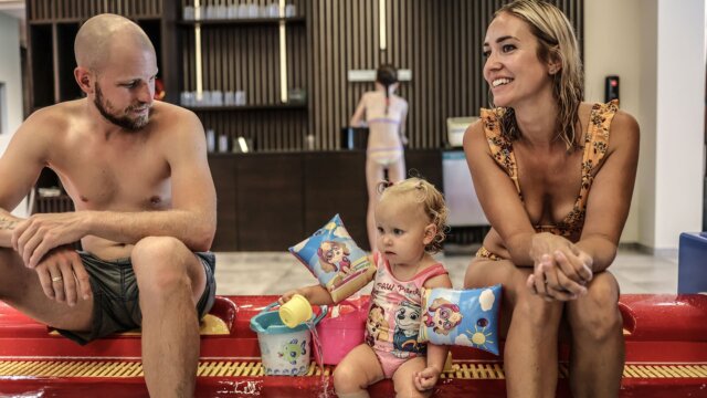 Familie mit Kind im Schwimmbereich.