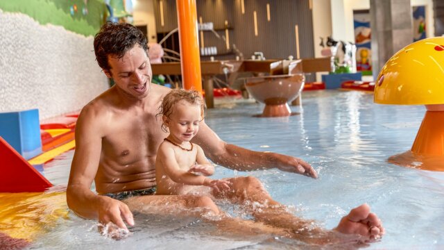 Vater spielt mit Kind im Wasserpark