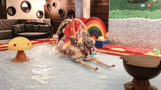Familie spielt im Wasserpark mit bunten Spielzeugen.