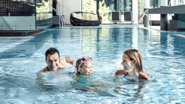 Familie schwimmt gemeinsam im Pool