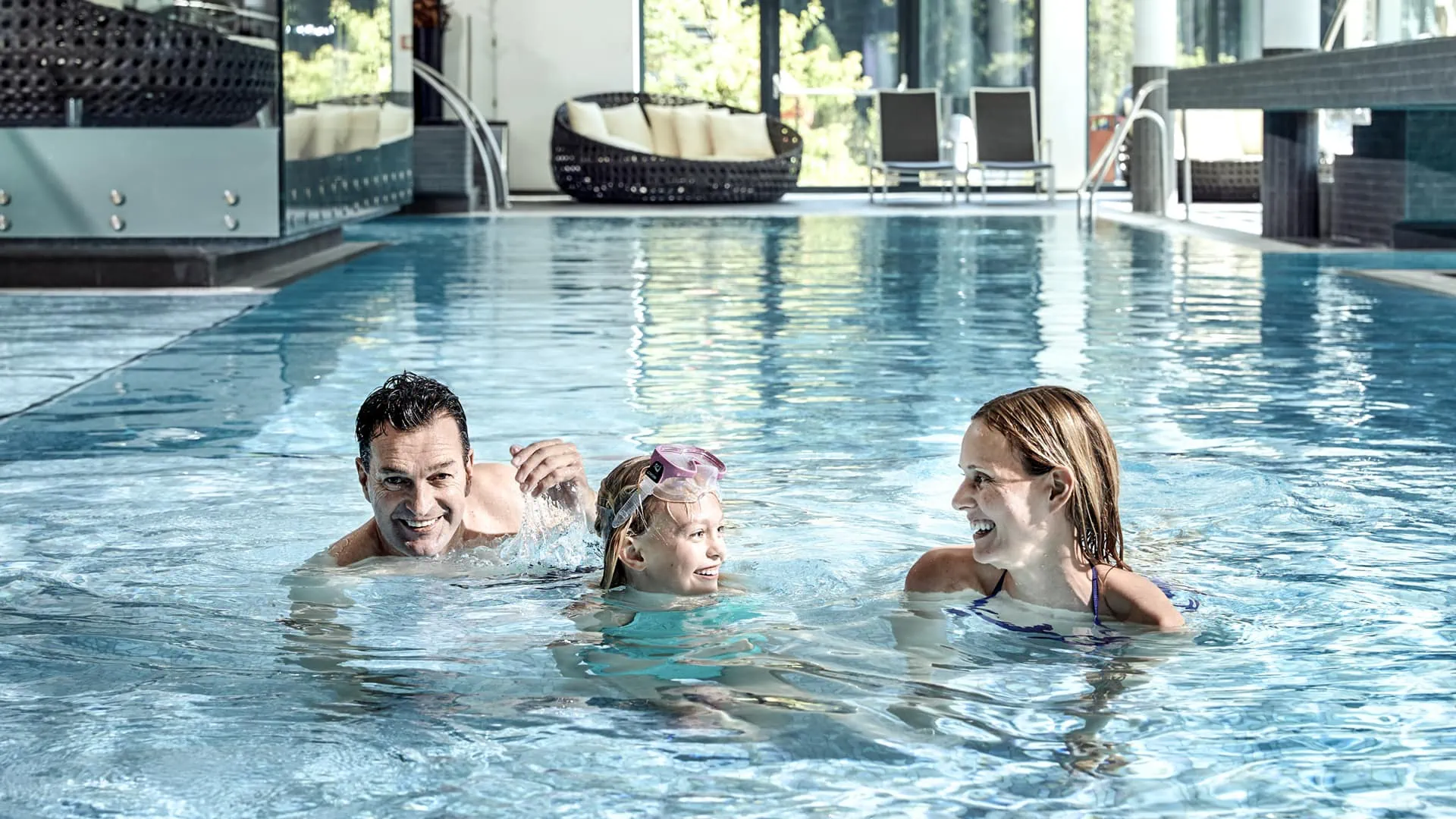 Familie schwimmt gemeinsam im Pool