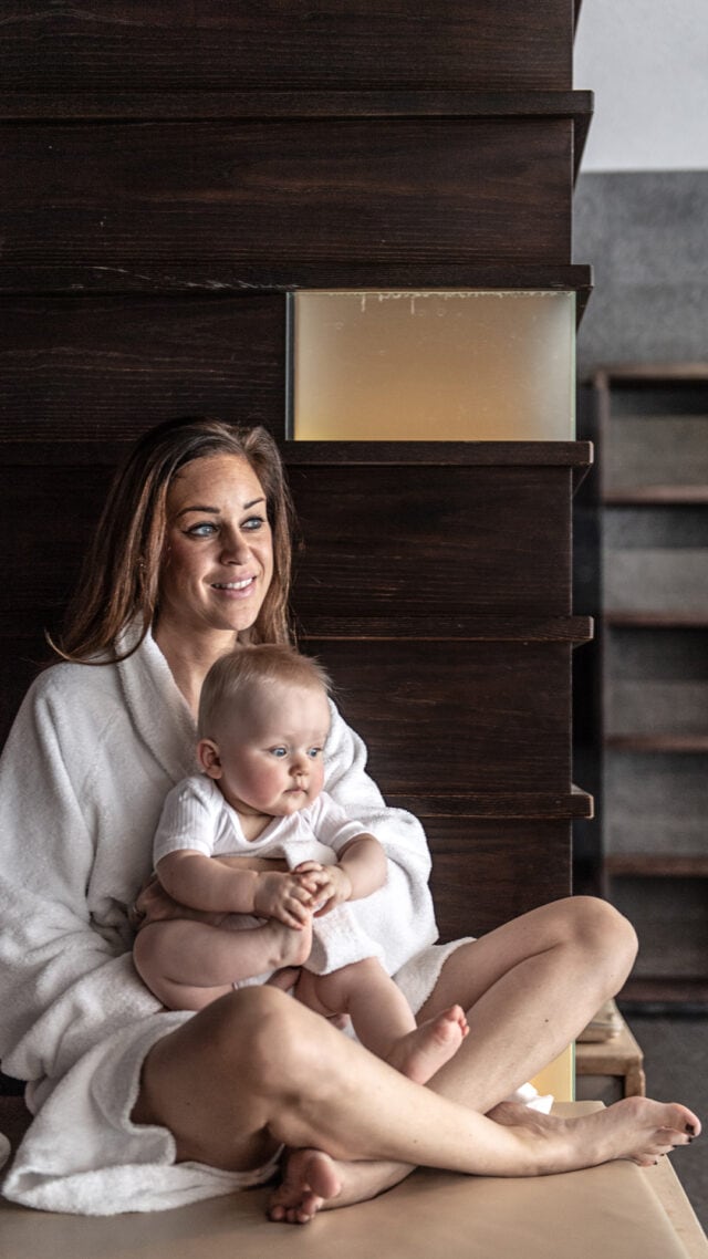 Frau mit Baby in einem gemütlichen Raum.
