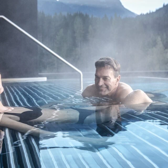 Paar entspannt im Wellnessbereich im Wasser.