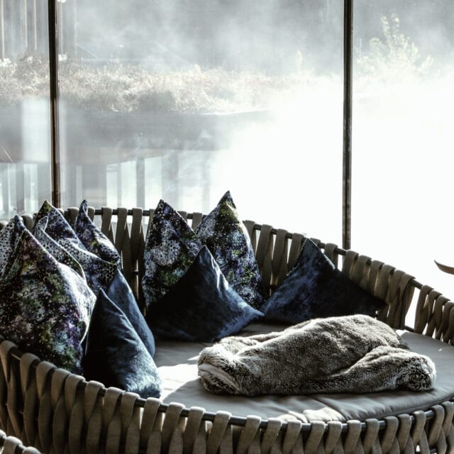 Gemütliche Sitzgelegenheit mit Kissen und Decke.