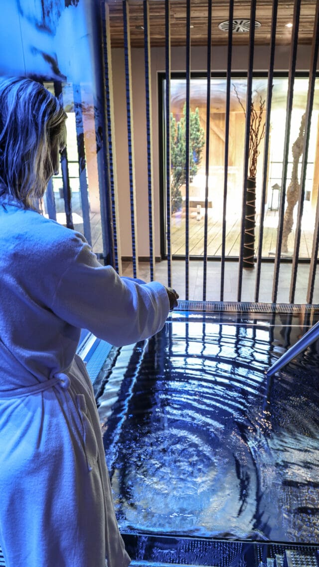 Frau im Bademantel am Wasserbecken
