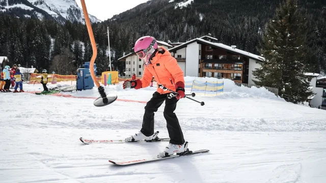 Skifahrendes Kind auf verschneiter Piste.