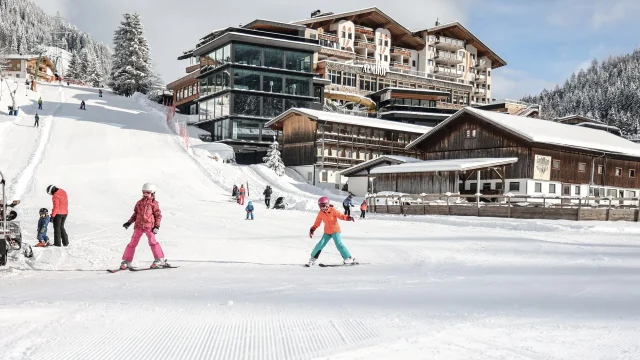 Kinder beim Skifahren in schneebedecktem Gebiet.