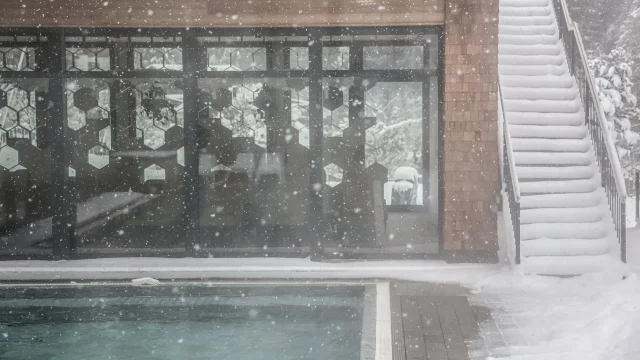 Schneebedecktes Gebäude neben einem Pool