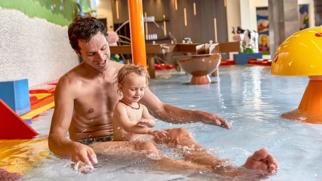 Vater spielt mit Kind im Wasserpark