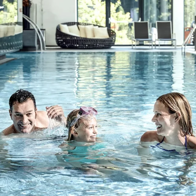 Familie schwimmt gemeinsam im Pool