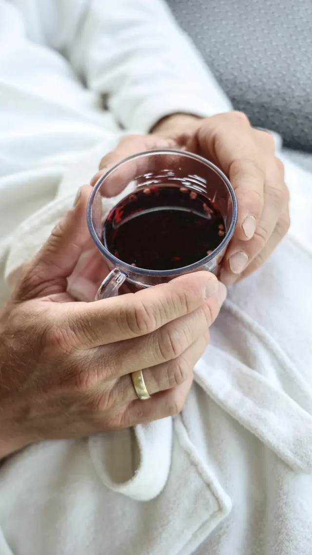 Eine Hand hält eine Tasse Rotwein.